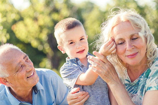 Grandparents with grandson enjoying time together in park.